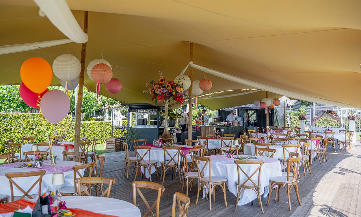 Feestelijk gedekte tafels onder een stretchtent van PartyHuren